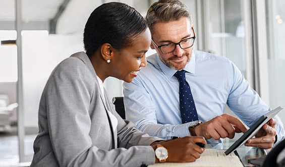 A man showing a woman something on his tablet