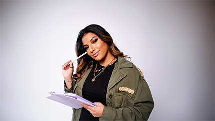 A woman smiling as she holds a purple iPad and an Apple pencil.