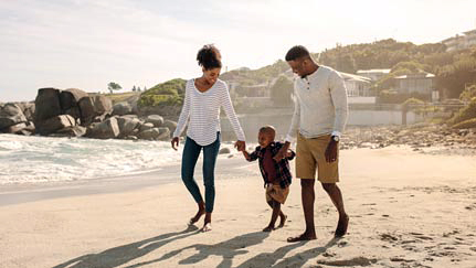 familia en la playa saltando rocas