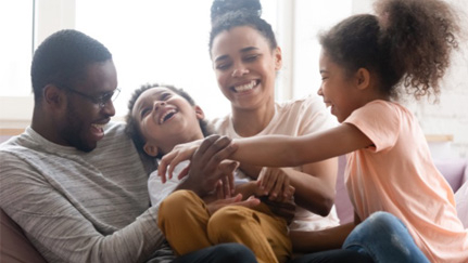 Young family plays together on a couch