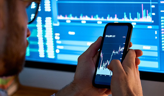 A person analyzing a chart on a mobile phone.