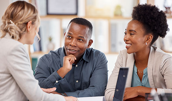 Couple and woman sitting at a table talking