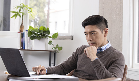 A man scrolls on a computer.