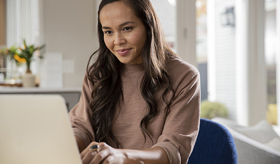 A woman types on a laptop.