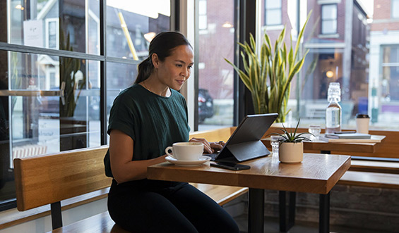 A woman types in a coffee shop.