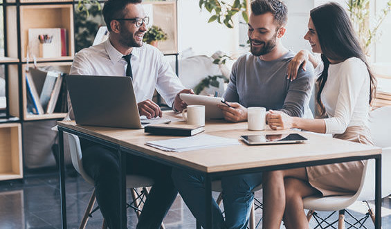 A couple speaks to a financial professional in a coffee shop.