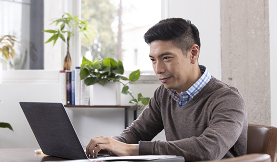 Man sitting at a desk on his laptop.