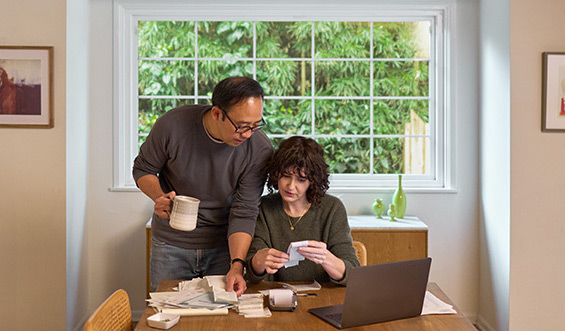 Two people checking calculations together at home