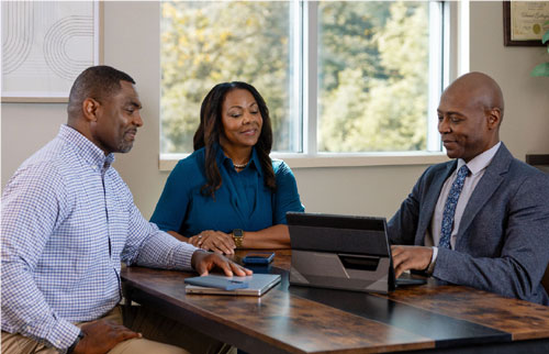 Couple sitting at a table talking with an advisor.