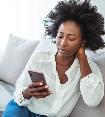 Woman sitting on the couch looking at her phone.