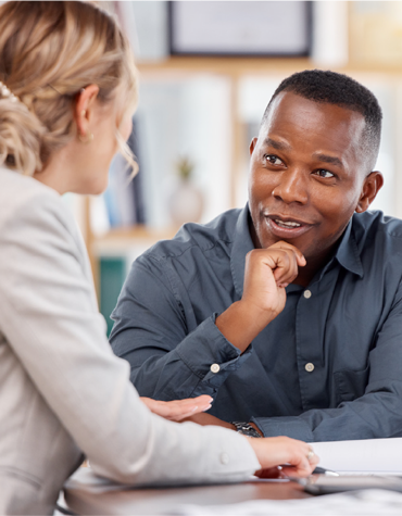 Man and woman sitting at a table talking.