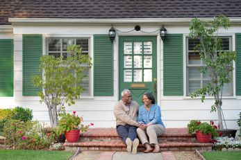 Couple sitting on the front porch of a home in Portland, OR