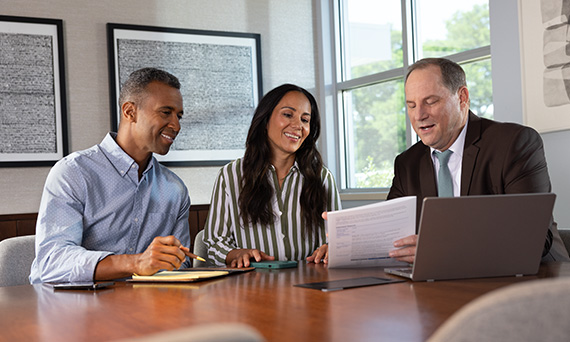A couple talking with an advisor looking at possibilities for their financial future